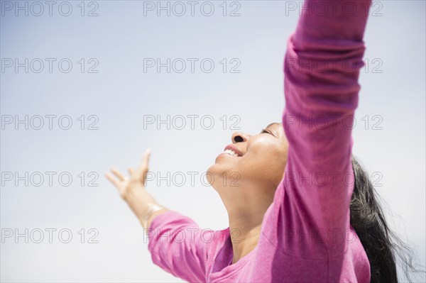 Mixed race woman with arms outstretched outdoors