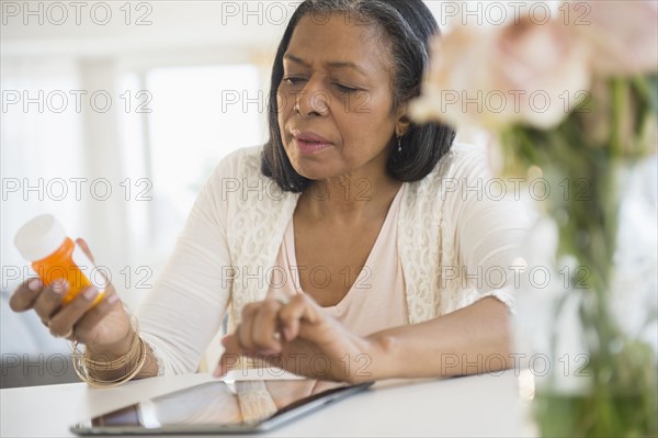 Mixed race woman researching medication on tablet computer