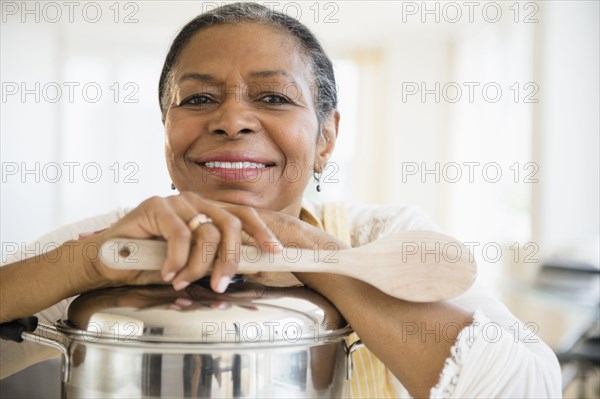 Mixed race woman cooking in kitchen