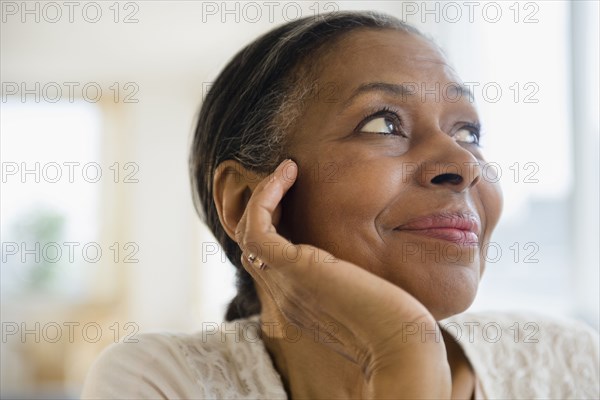 Close up of mixed race woman resting chin in hand