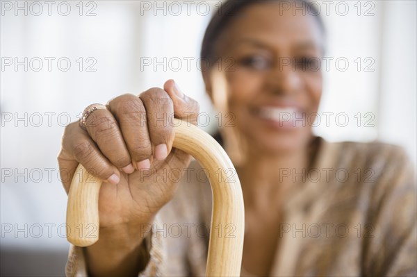 Mixed race woman holding cane