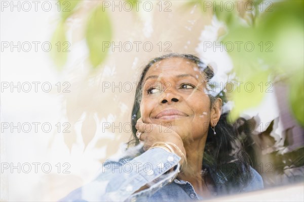 Mixed race woman looking out window