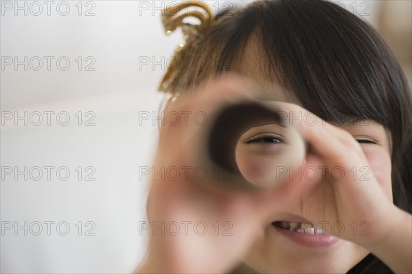 Filipino girl looking through cardboard tube