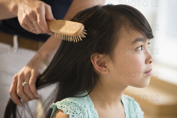 Mother brushing daughter's hair