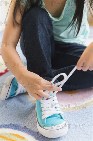 Filipino girl tying her shoelaces