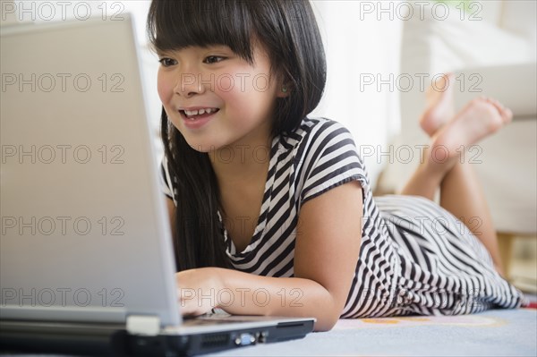 Filipino girl using laptop on floor