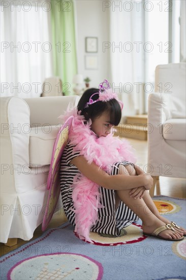Filipino girl playing dress-up in living room