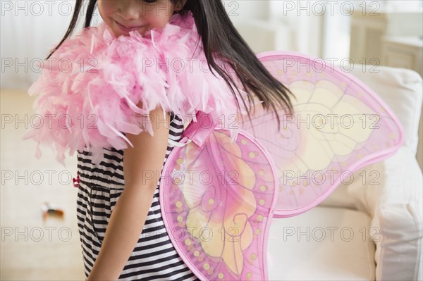 Filipino girl playing dress-up in living room