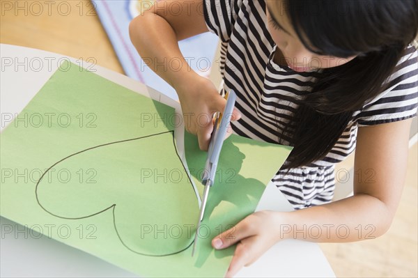 Filipino girl cutting heart shape out of paper