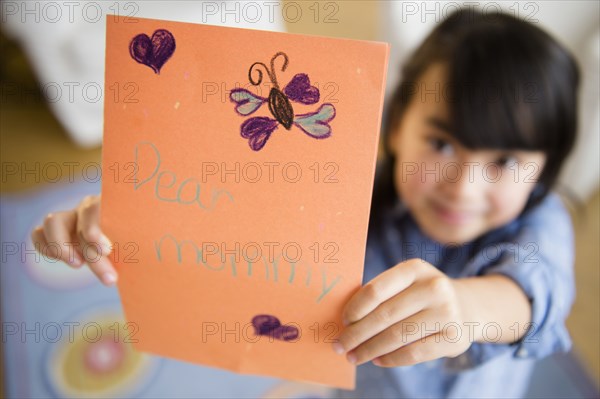 Close up of Filipino girl holding card for mother