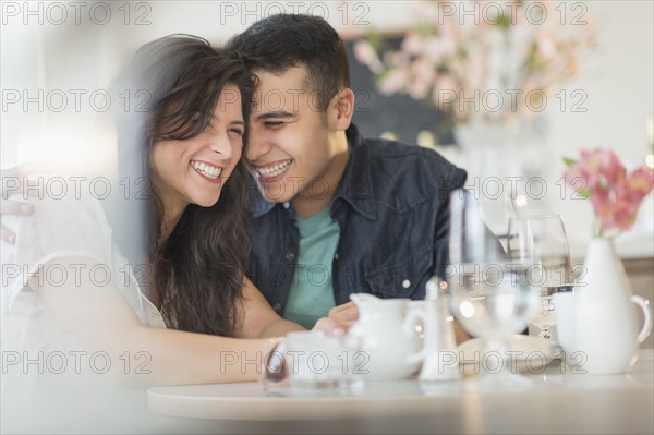 Hispanic couple laughing in cafe