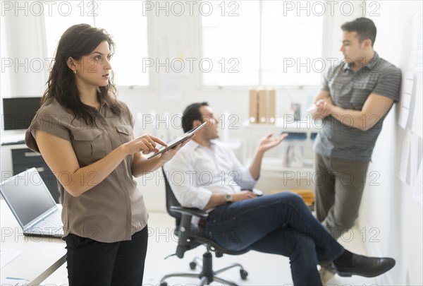Hispanic businesswoman using tablet computer in office