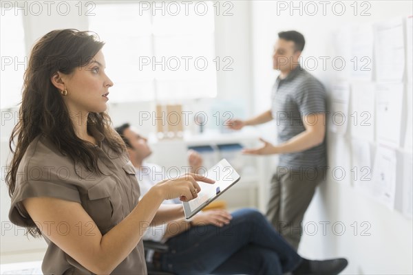 Hispanic businesswoman using tablet computer in office