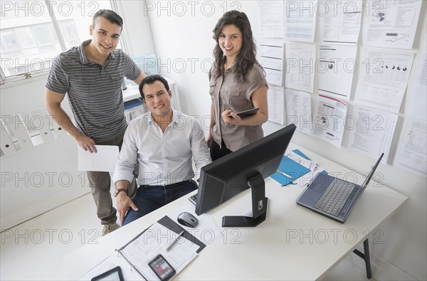 Hispanic business people smiling in office