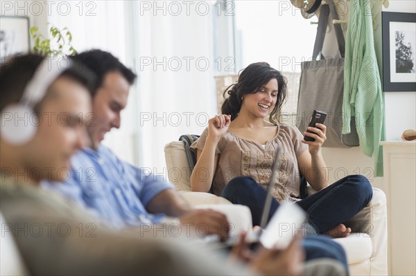 Hispanic friends using technology in living room