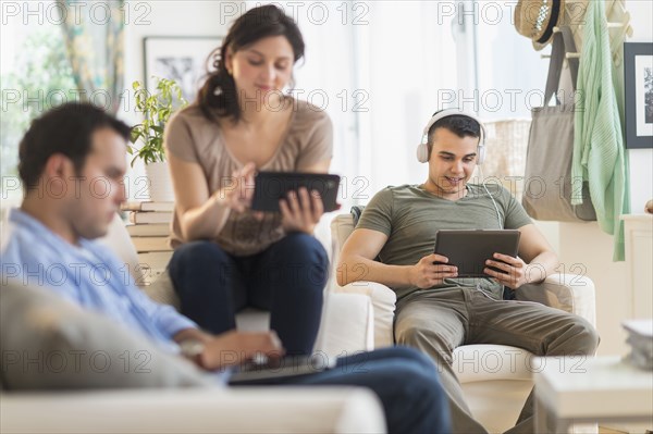 Hispanic friends using technology in living room