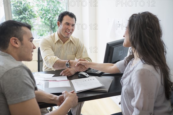 Hispanic businessman shaking hands with client in office