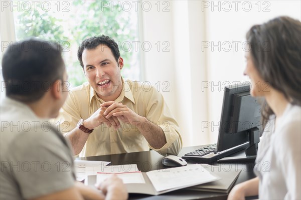 Hispanic businessman talking to clients in office