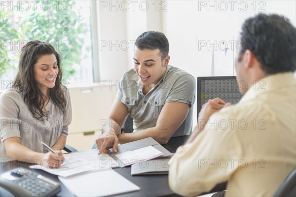 Hispanic businessman talking to clients in office