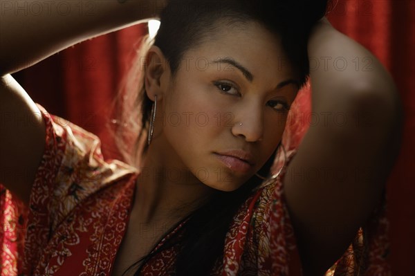 Mixed race woman near curtain