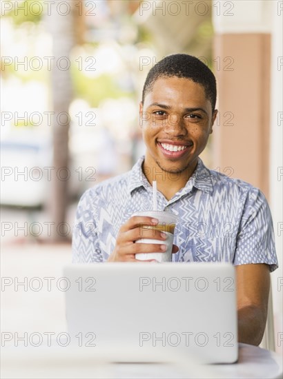 African American man using laptop in cafe