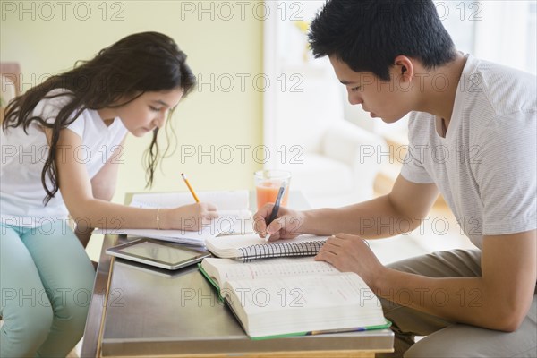 Hispanic brother and sister doing homework