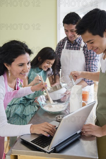 Hispanic family baking in kitchen