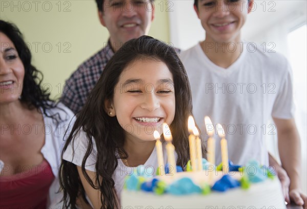 Hispanic girl admiring birthday cake