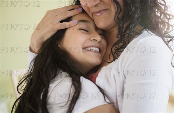 Hispanic mother and daughter hugging