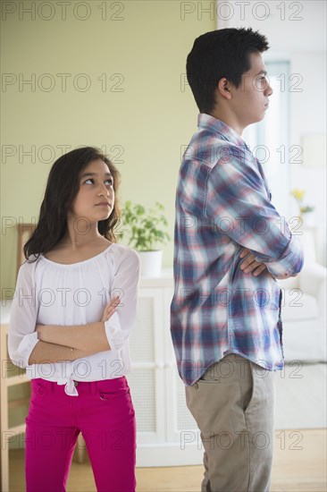 Hispanic brother and sister fighting in living room