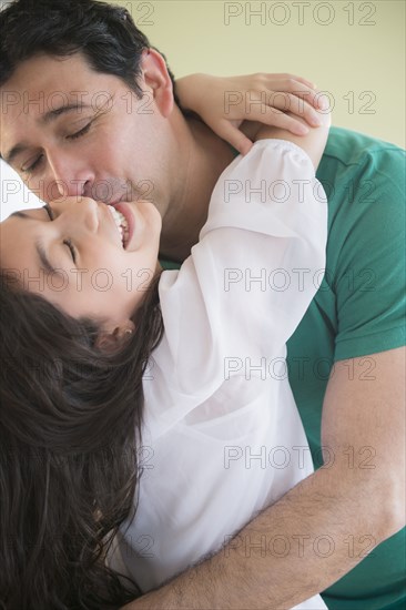 Hispanic father kissing daughter on cheek