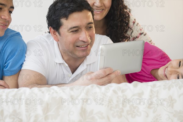 Hispanic family using digital tablet together