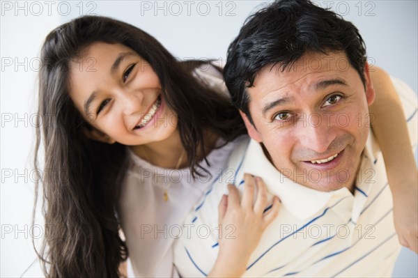 Hispanic father carrying daughter piggyback