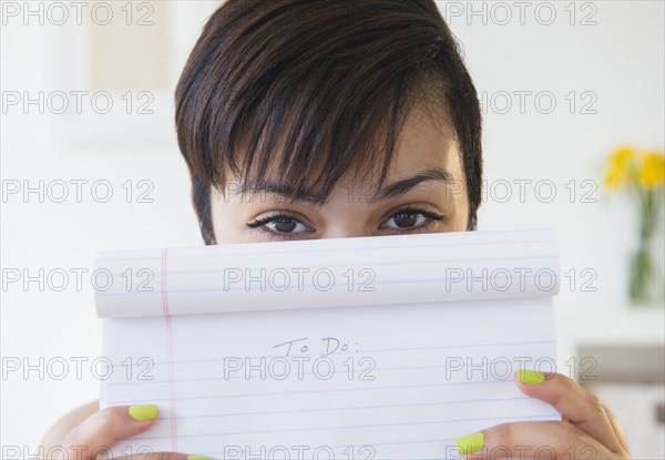 Mixed race woman holding empty to do list