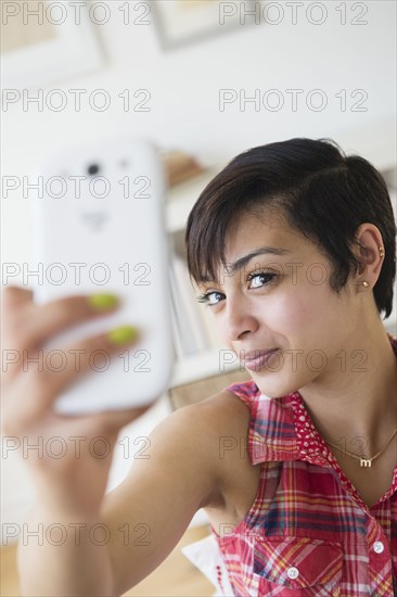 Mixed race woman taking selfie with cell phone