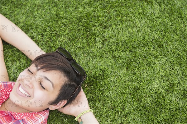 Mixed race woman laying in grass outdoors