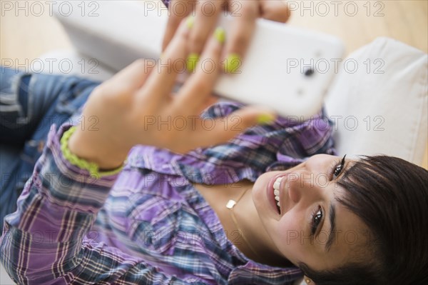 Mixed race woman taking selfie with cell phone