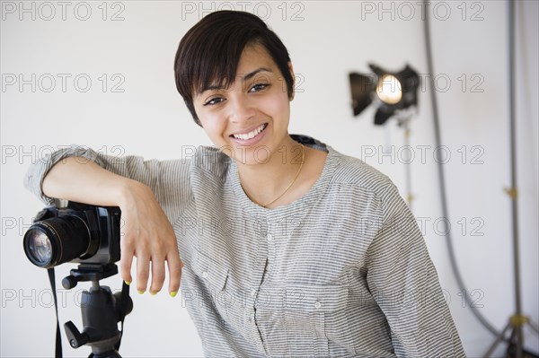 Mixed race photographer smiling in studio