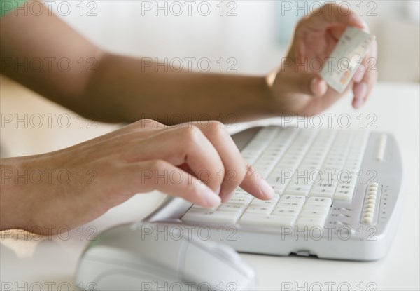 Mixed race man shopping online with credit card