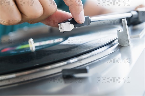 Close up of mixed race man playing vinyl record