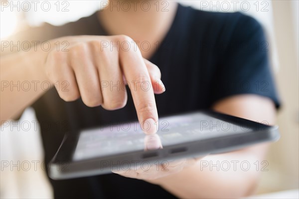 Close up of mixed race man using digital tablet