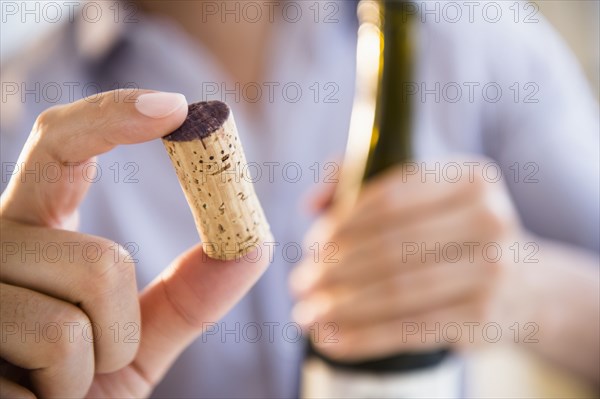 Close up of mixed race man holding wine cork
