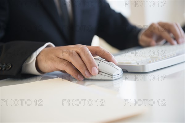 Close up of mixed race businessman using wireless mouse and keyboard