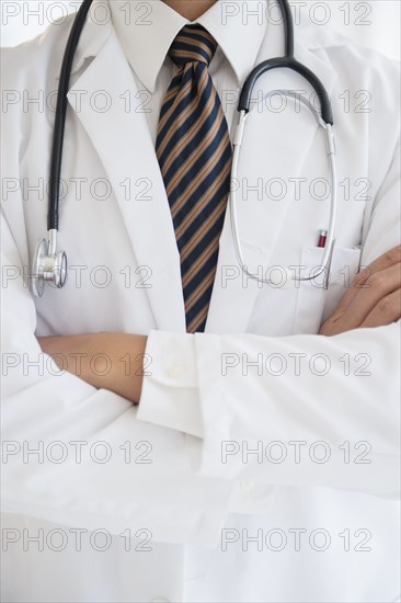 Close up of mixed race doctor with arms crossed