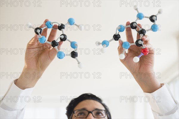 Close up of mixed race scientist holding molecular models
