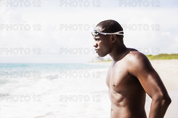 Mixed race swimmer wearing goggles at beach