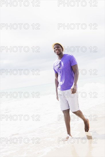 Mixed race man walking on beach