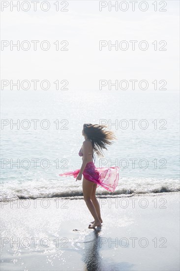 Caucasian woman wading at beach