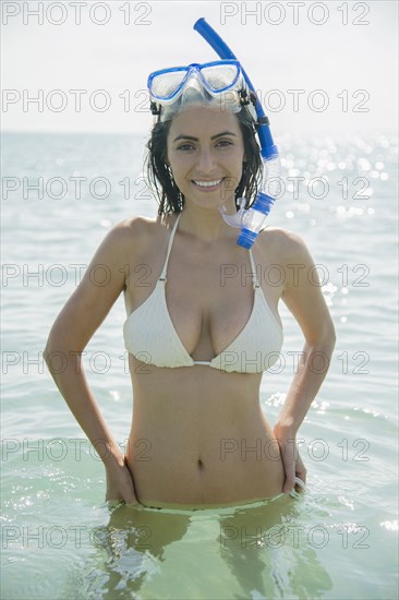 Caucasian woman wearing snorkel and mask in ocean