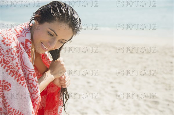 Caucasian woman wringing hair on beach